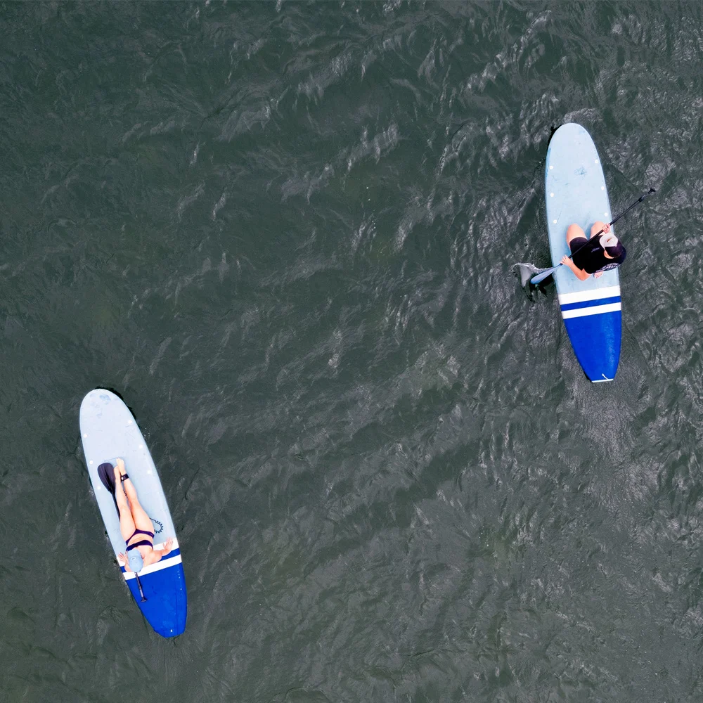 A top-down aerial view of two sup paddle boarders